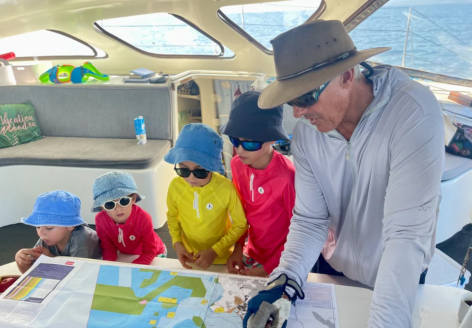 Anthony showing young guests the reef chart in the saloon