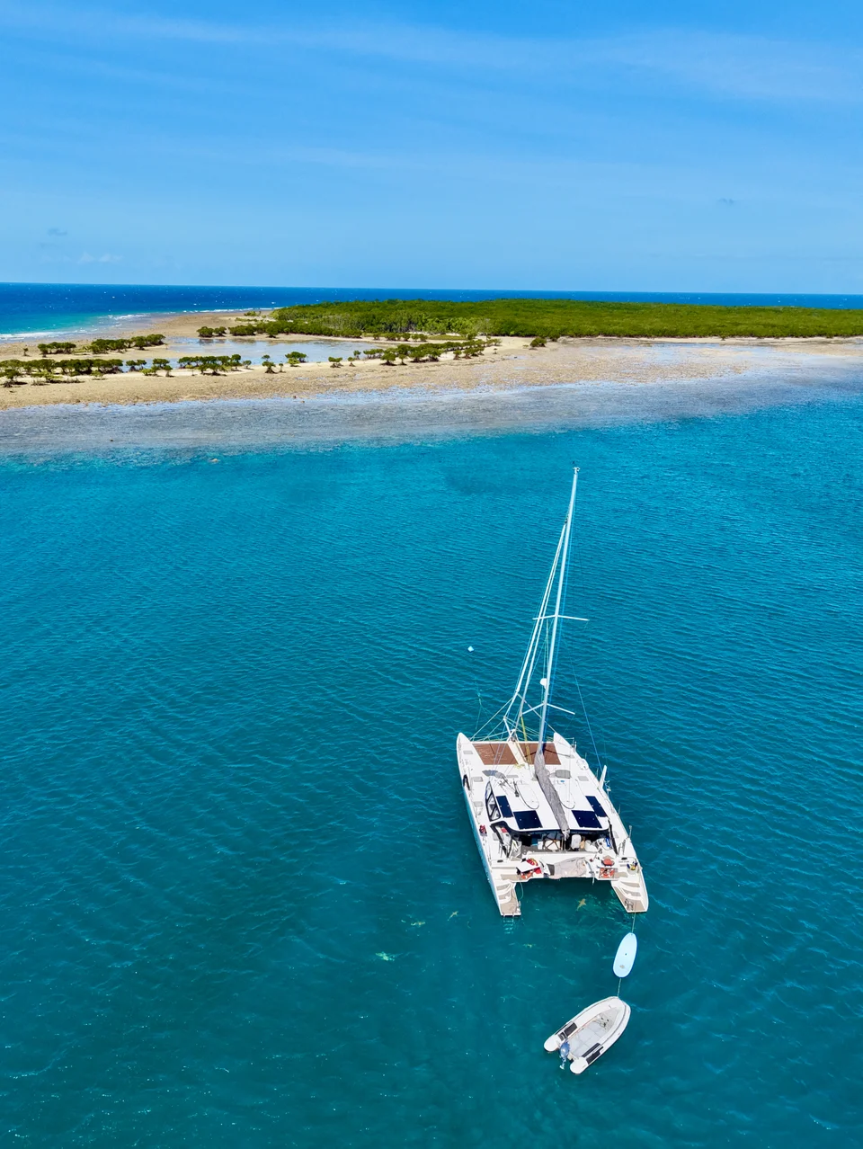 Liquid Desire anchored beside a sand cay