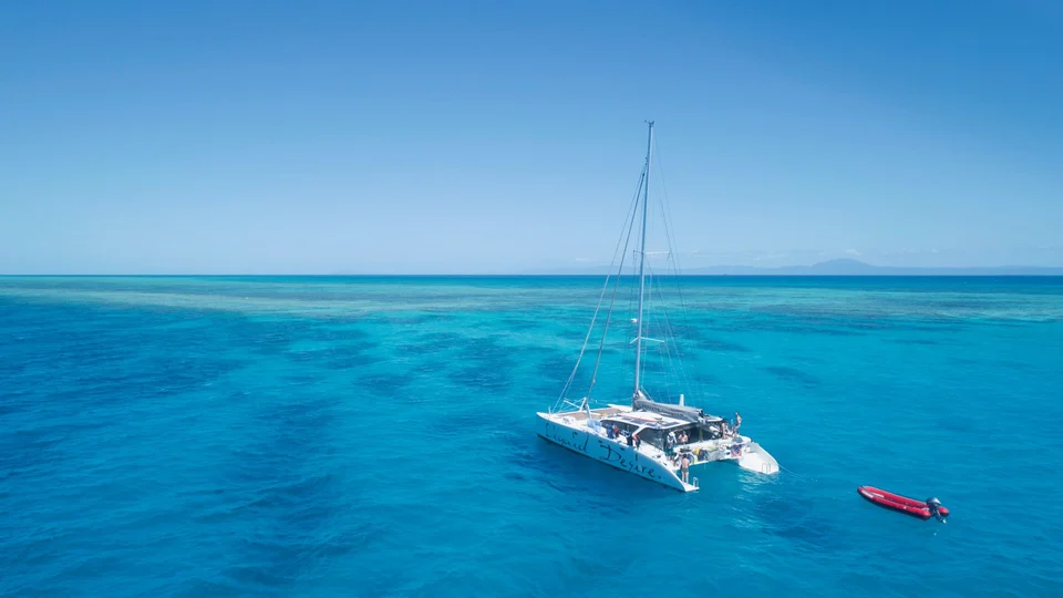 Liquid Desire and the dinghy over the reef