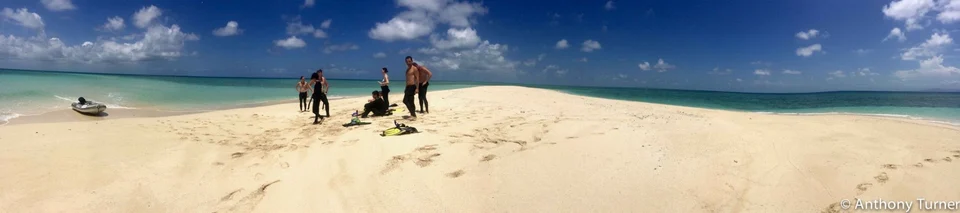 Guests walking on a sand cay