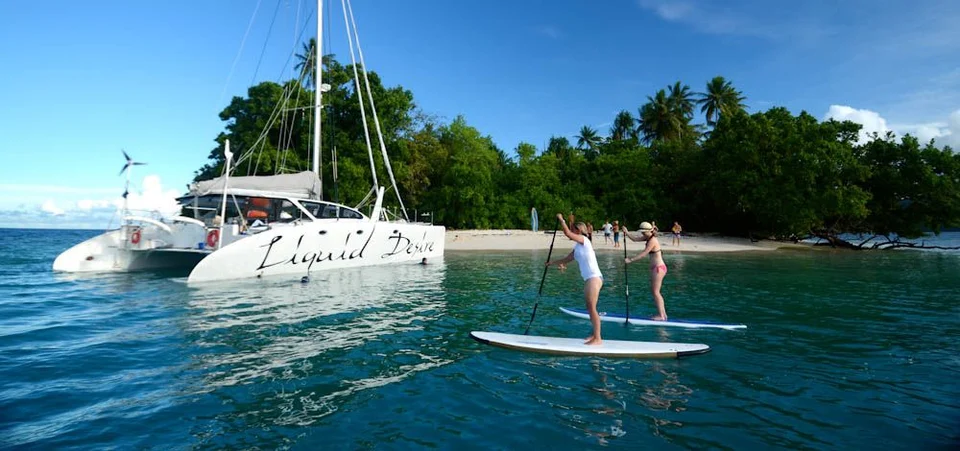 Paddleboarding beside Liquid Desire