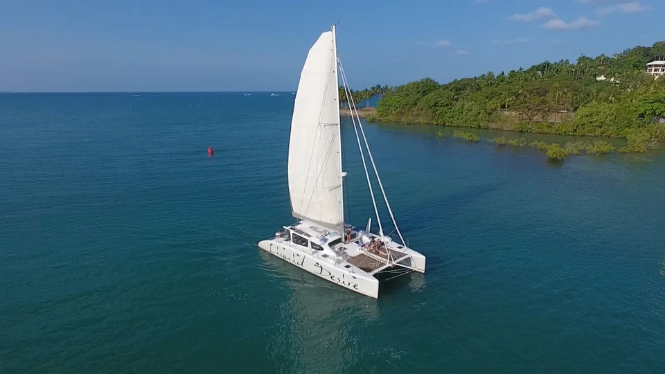 Liquid Desire under sail near an island
