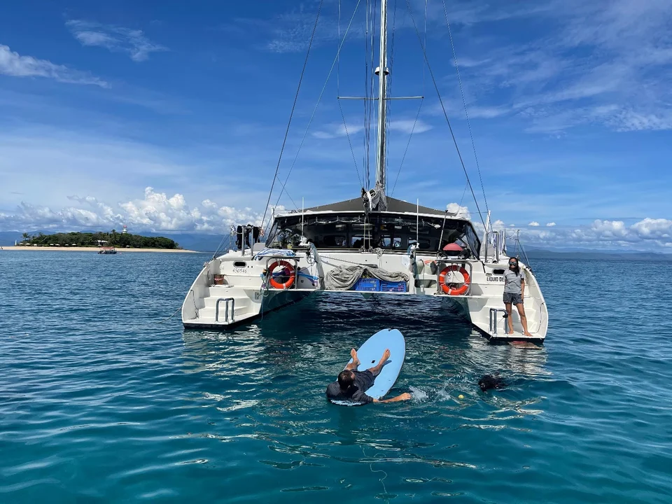 The yacht and a paddleboard from astern